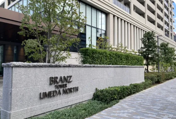 「地下鉄中津駅南」の交差点を渡ってすぐに右折。道沿いにあるブランズタワー梅田ノース、ファミリーマート、セブンイレブンの前を通過する。