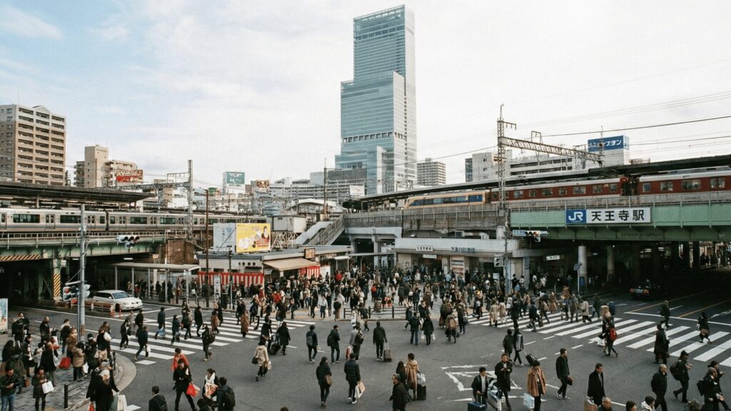 正月休み明けで賑わう大阪・天王寺駅前のスクランブル交差点とあべのハルカス。複数の路線が集まるターミナル駅としてのアクセスの良さを示す様子。