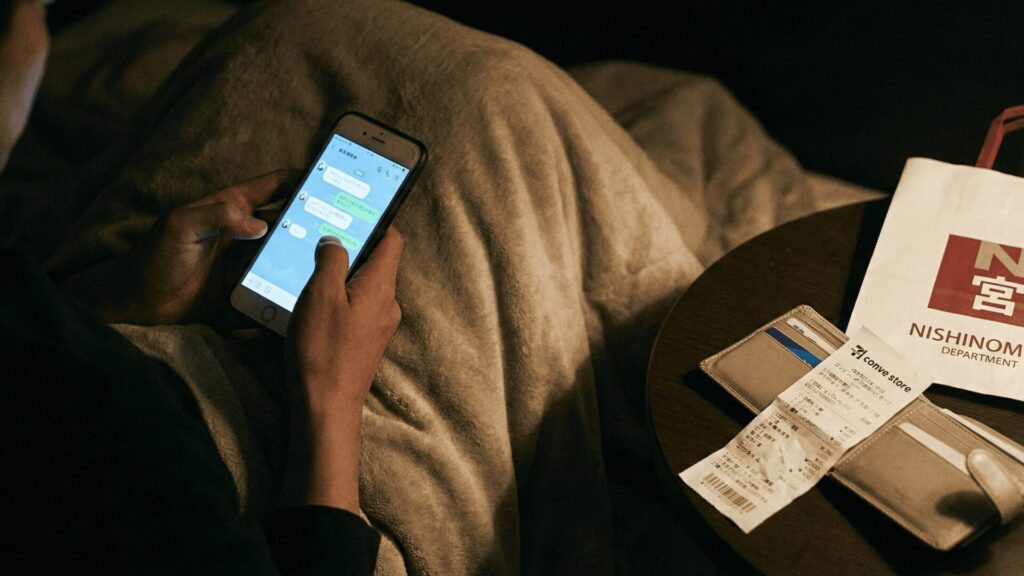 夜中にこっそりスマホで連絡を取り合う様子と、西宮のお土産やレシートから浮気の証拠が見つかるイメージ