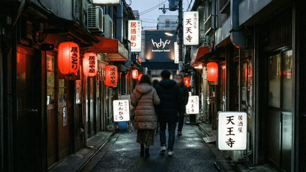 大阪天王寺駅北側の裏路地（裏天王寺）にある隠れ家的な飲食店街を通り、人目を避けてホテル街へ向かう不倫カップルの後ろ姿