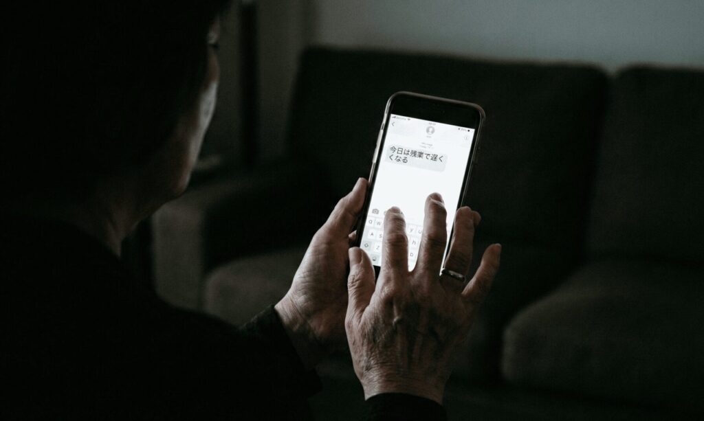 残業を伝えるパートナーからのメッセージを見て悩む女性