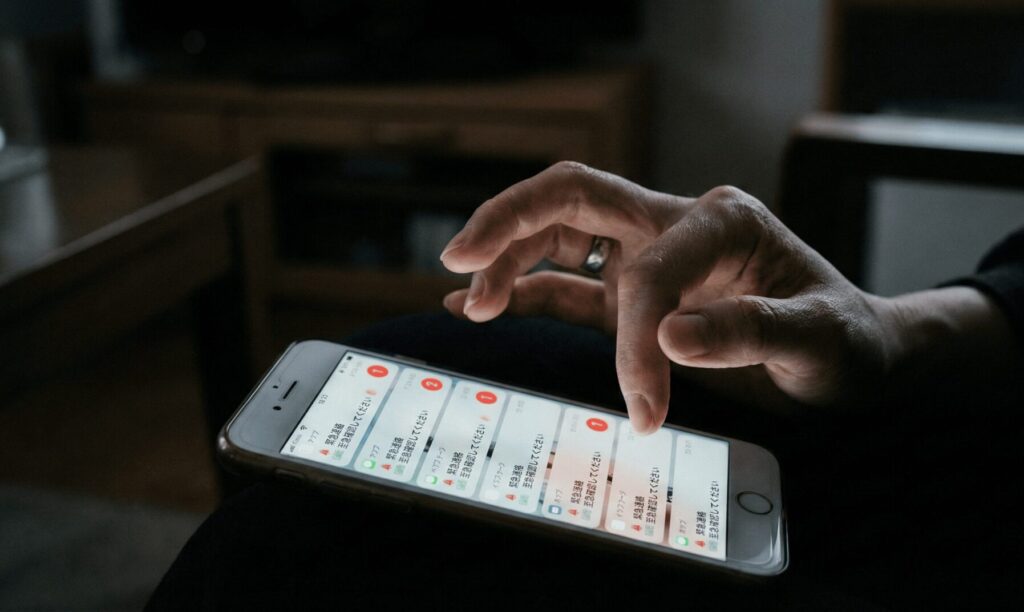 知人からの目撃談をスマートフォンで確認し動揺する女性